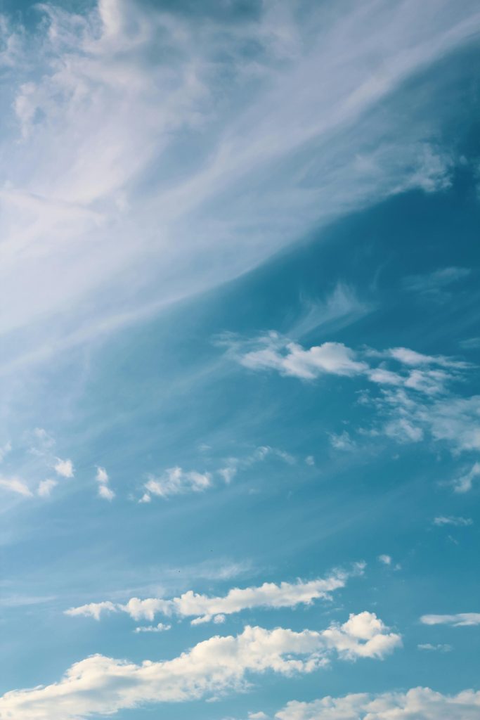 Peaceful sky with wispy clouds drifting in the blue, evoking serenity and calmness.
